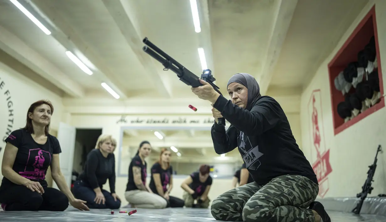 Svetlana Putilina berlatih menggunakan pistol di Kharkiv, Ukraina (30/1/2022). Putilina, yang suaminya adalah seorang Muslim di militer Ukraina. (AP Photo/Evgeniy Maloletka)