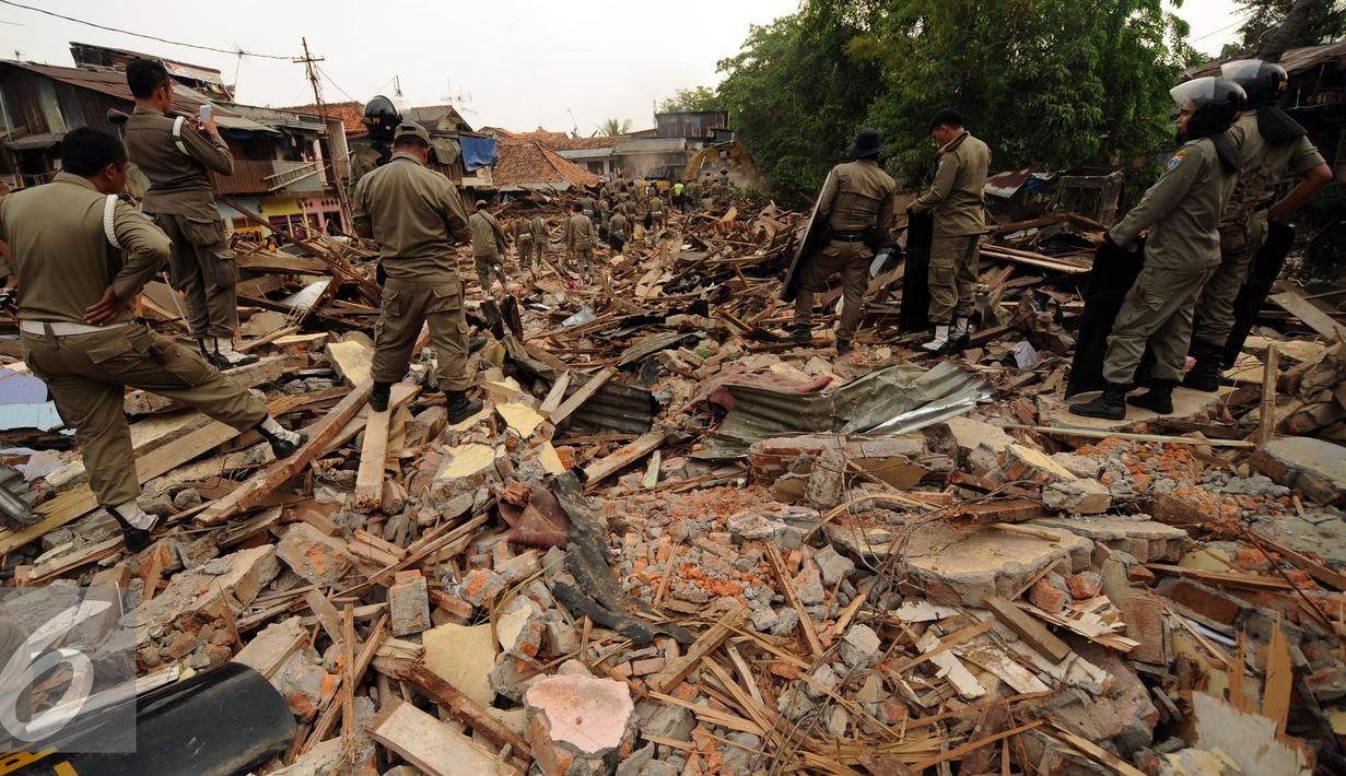 Petugas Satpol PP bersiap mengamankan proses penggusuran rumah warga di Kampung Pulo, Jakarta, Kamis (20/8/2015). 2200 personil gabungan dari Kepolisian dan Satpol PP dikerahkan untuk mengamankan penggusuran tersebut. (Liputan6.com/HelmiFithriansyah)