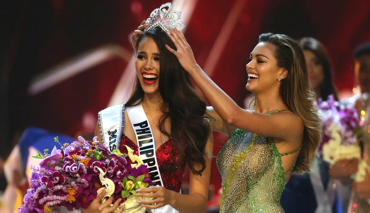 Miss Filipina Catriona Gray bereaksi saat Miss Universe 2017, Demi-Leigh Nel-Peters menyematkan mahkota Miss Universe 2018 pada babak grand final di Bangkok, Thailand, Senin (17/12). Catriona dinobatkan sebagai Miss Universe ke-67. (AP/Gemunu Amarasinghe)