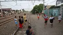 Suasana di pinggir rel kereta api di kawasan Kemayoran, Jakarta, Senin (24/7). Minimnya lahan bermain menyebabkan anak-anak terpaksa bermain di lokasi tersebut, meskipun berbahaya bagi keselamatan. (Liputan6.com/Immanuel Antonius)