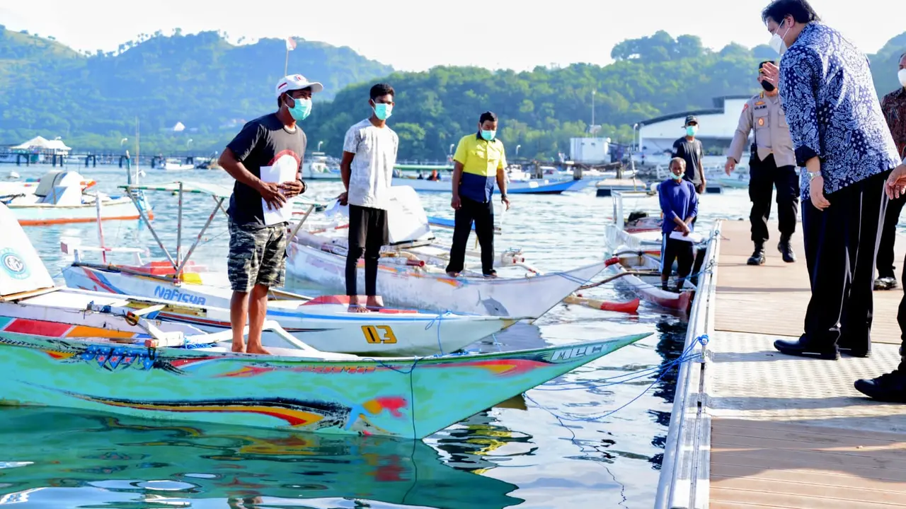 Menteri Koordinator Bidang Perekonomian Airlangga Hartarto menyerahkan Bantuan Tunai Pedagang Kaki Lima, Warung, dan Nelayan (BT-PKLWN) secara langsung di Tempat Pelelangan Ikan Labuan Bajo, Manggarai Barat, Nusa Tenggara Timur, Senin (14/3/2022).  (Sumbe