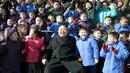 Pemimpin Korut, Kim Jong Un foto bersama dengan anak-anak yatim saat mengunjungi Sekolah Dasar Anak Yatim di Pyongyang, Korea Utara (2/2). (AFP Photo / KCNA VIA KNS / STR)