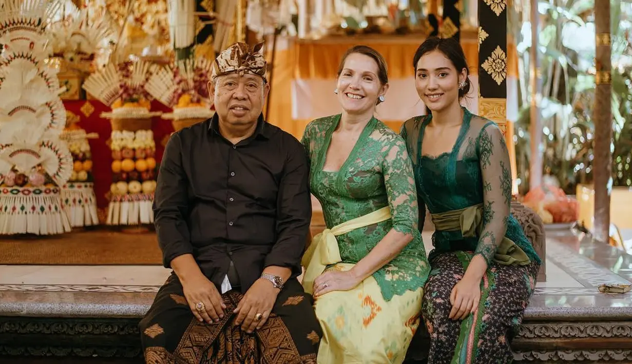 <p>Berpose bersama kedua orangtuanya, Laksmi Shari terlihat kembali mengenakan kebaya Bali dengan model yang lebih sederhana. Kebaya Bali kali ini berwarna hijau tua dengan bagian lengan yang transparan, dipadu kain bermotif sebagai bawahan, dan selendang hijau Army yang dililitkannya di pinggang. Foto: Instagram.</p>