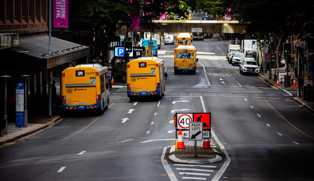 Bus berjalan di sepanjang jalan di Brisbane, Australia (30/6/2021). Kota itu menjadi sunyi karena dari penguncian dengan Australia memerangi wabah varian Delta yang sangat menular dari Covid-19. (AFP/Patrick Hamilton)