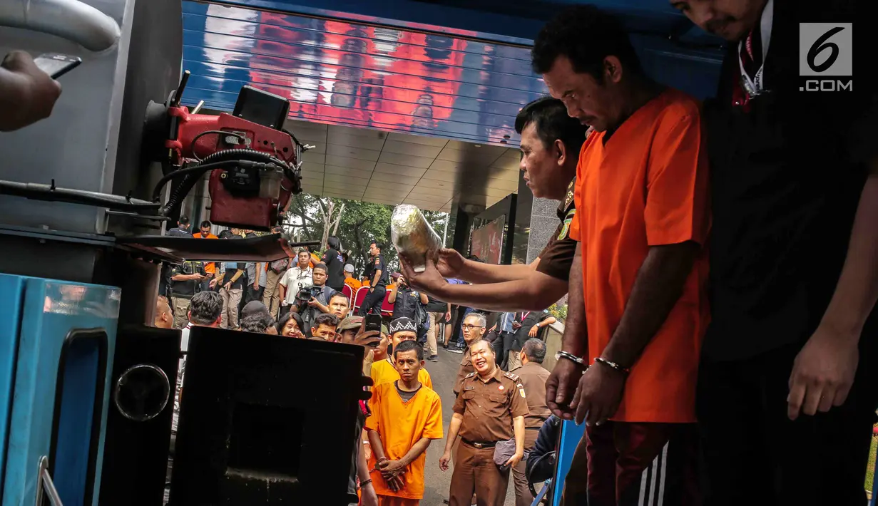 Tersangka bersiap memasukkan barang bukti narkoba ke dalam mesin insimilator saat pemusnahan di Bareskrim Mabes Polri, Jakarta, Selasa (9/7/2019). Bareskrim Polri memusnahkan 177,5 Kg sabu dan 30 ribu butir ekstasi yang disita dari jaringan Malaysia-Indonesia. (Liputan6.com/Fazail Fanani)