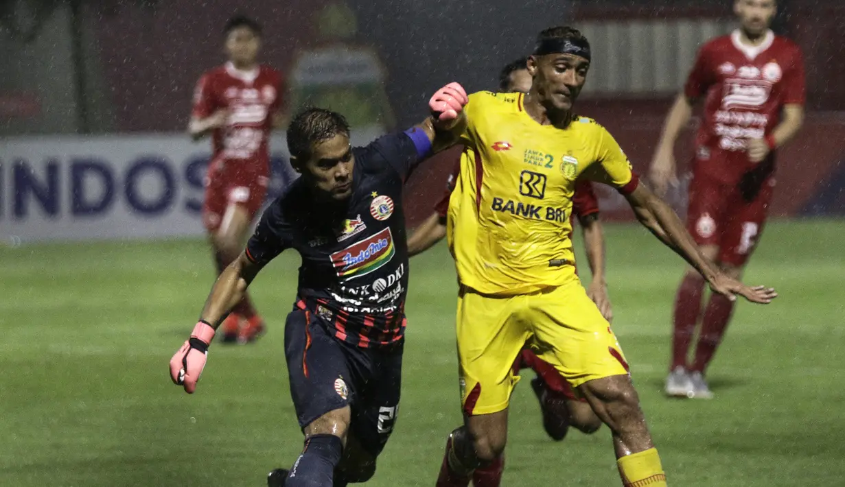 Gelandang Bhayangkara FC, Bruno Matos, berebut bola dengan kiper Persija Jakarta, Andritany Ardhiyasa, pada laga Shopee Liga 1 di Stadion PTIK, Senayan, Jakarta, Rabu (4/12). Bhayangkara menang 3-0 atas Persija. (Bola.com/Yoppy Renato)