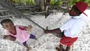 Anak-anak suku Byak Betew bermain di tepi pantai di pulau Saukabu, satu dari 1.500 pulau di Raja Ampat 20 Agustus 2017. Raja Ampat merupakan rumah bagi sekitar 1.400 jenis ikan dan 600 spesies karang. (AFP Photo/Goh Chai Hin)