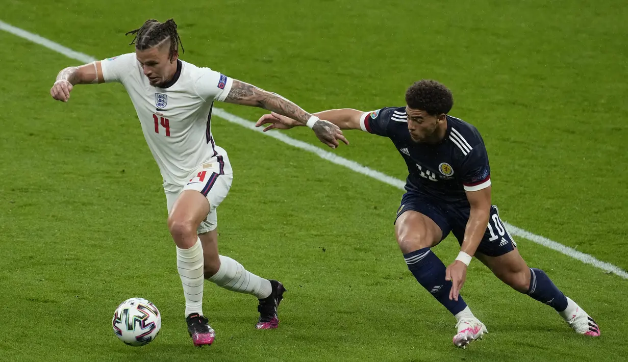 Gelandang Inggris, Kalvin Phillips membawa bola dari kejaran penyerang Skotlandia, Che Adams pada pada pertandingan grup D Euro 2020 di stadion Wembley, di London, Jumat (18/6/2021). Tambahan satu poin lawan Skotlandia membuat Inggris kini mengoleksi empat poin. (AP Photo/Matt Dunham, Pool)