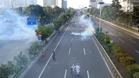 Massa menghindari gas air mata saat bentrok dengan polisi di jalan tol dalam kota di kawasan Slipi, Jakarta, Rabu (22/5/2019). Jalan tol  dalam kota sempat ditutup sekitar setengah jam, dan massa dihalau petugas ke arah kemanggisan. (merdeka.com/Arie Basuki)