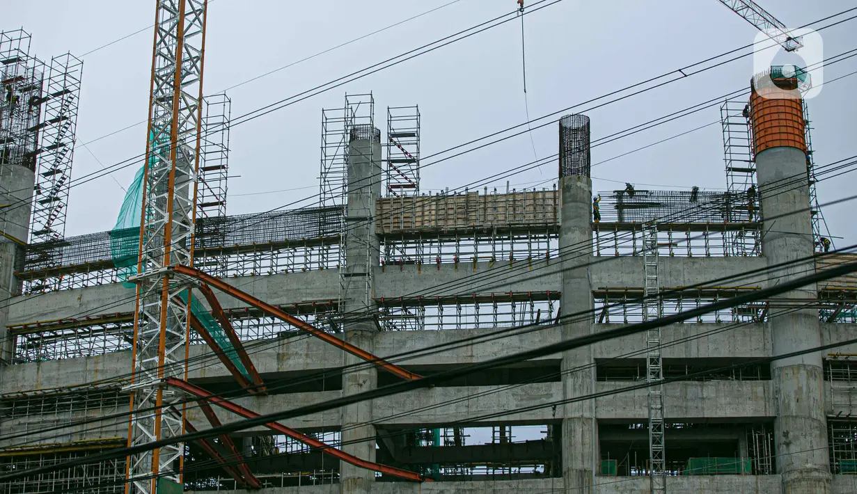 Aktivitas pekerja proyek pembangunan Jakarta International Stadium atau Stadion BMW di kawasan Papanggo, Tanjung Priok, Jakarta, Senin (18/1/2021). Progres pembangunan Jakarta International Stadium atau Stadion BMW ditargetkan rampung pada Oktober 2021. (Liputan6.com/Faizal Fanani)