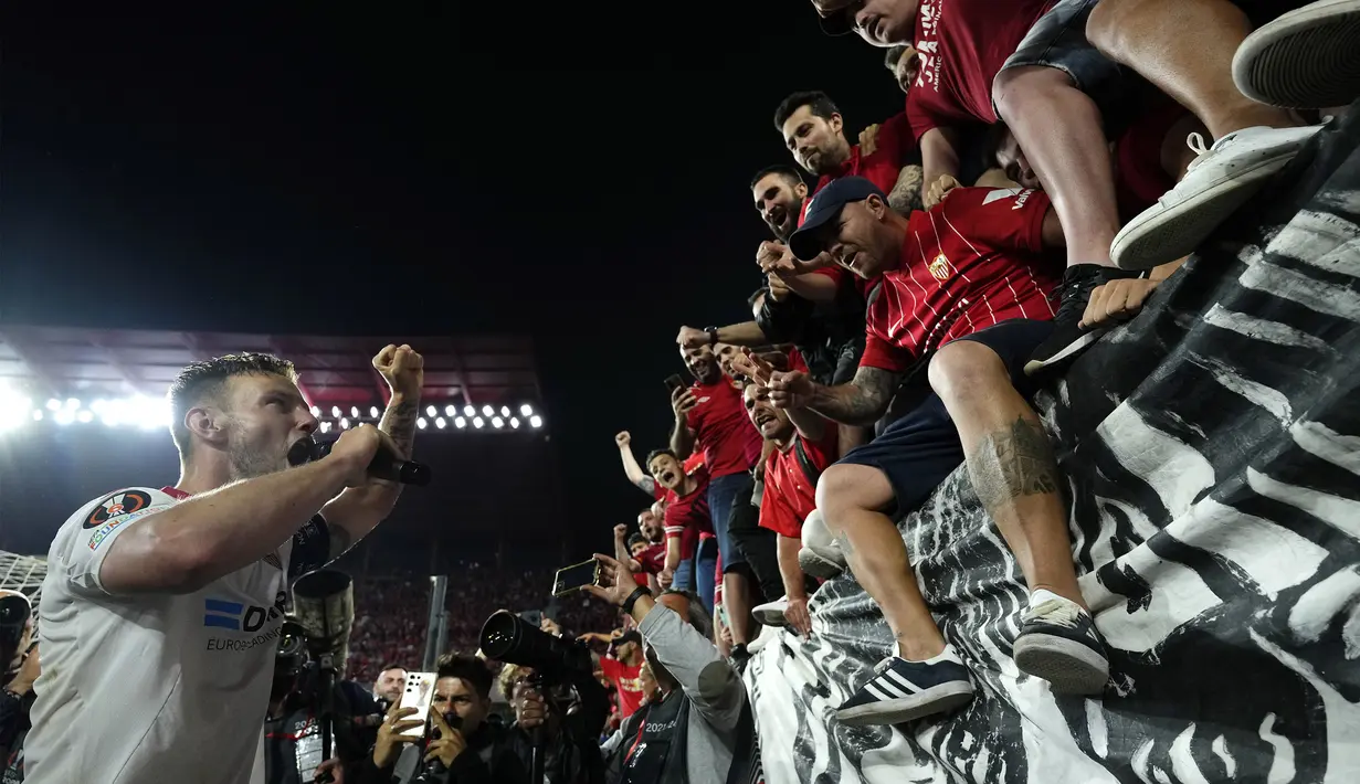 Kapten tim Sevilla, Ivan Rakitic (kiri), merayakan kemanagan bersama para penggemar setelah mengalahkan Juventus dalam pertandingan leg kedua semifinal Liga Europa 2022/2023 di Estadio Ramos Sanchez Pizjuan, Jumat (19/05/2023) dini hari WIB. (AP Photo/Jose Breton)