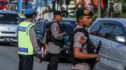 Personel Brimob bersenjata laras panjang ikut mengatur lalu lintas di kawasan jalur arus balik Pantura, Tegal, Jawa Tengah, Jumat (30/6). (Liputan6.com/Faizal Fanani)