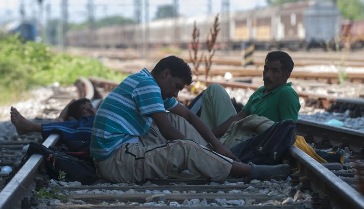 Imigran menunggu kereta ke Serbia di kota Gevgelija, wilayah perbatasan Macedonia-Yunani, Kamis (9/7/2015). Mereka menempuh ribuan kilometer agar dapat mengejar kereta api tujuan Serbia. (AFP PHOTO/Robert ATANASOVSKI)