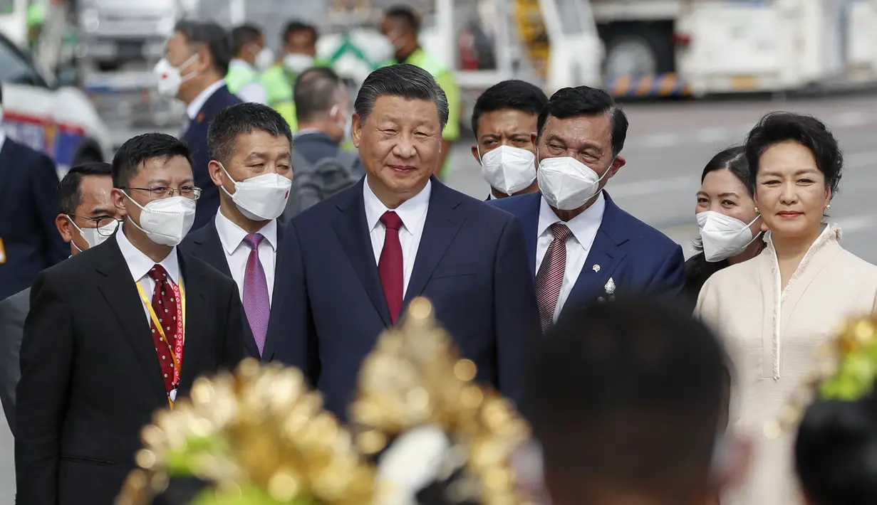Presiden China Xi Jinping dan istrinya Peng Liyuan disambut Menko Marves Luhut Binsar Pandjaitan setibanya di Bandara Internasional Ngurah Rai menjelang KTT G20 di Bali, Senin (14/11/2022). (Ajeng Dinar Ulfiana/Pool Photo via AP)