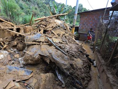 Seorang warga meninggalkan daerah tersebut setelah menerima perintah evakuasi menyusul tanah longsor di Bello, Distrik Antioquia, Kolombia, pada tanggal 25 Juni 2025. (JAIME SALDARRIAGA/AFP)
