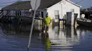 Nathan Fabre memeriksa rumah dan kapalnya yang hancur akibat Badai Ida pada Minggu (5/9/2021). Banjir bandang menewaskan sedikitnya 44 orang di empat negara bagian AS saat sisa-sisa Badai Ida menyulut hujan deras. (AP Photo/John Locher)