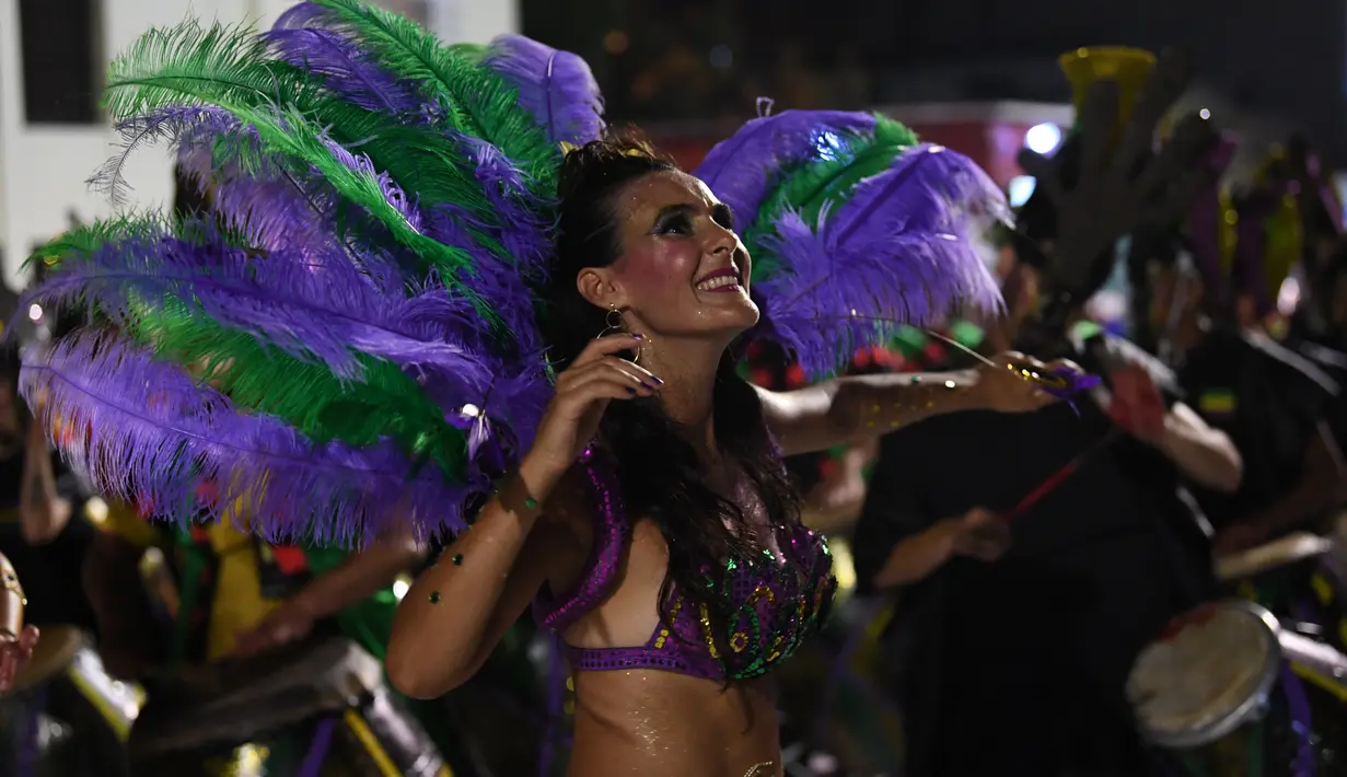 Anggota karnaval Uruguay, Comparsa, melakukan pertunjukkan tari selama parade karnaval Llamadas di Montevideo, Kamis (7/2). Para penari dengan menggunakan berbagai kostum menarik meriahkan parade tersebut di jalanan Montevideo. (PABLO PORCIUNCULA/AFP)
