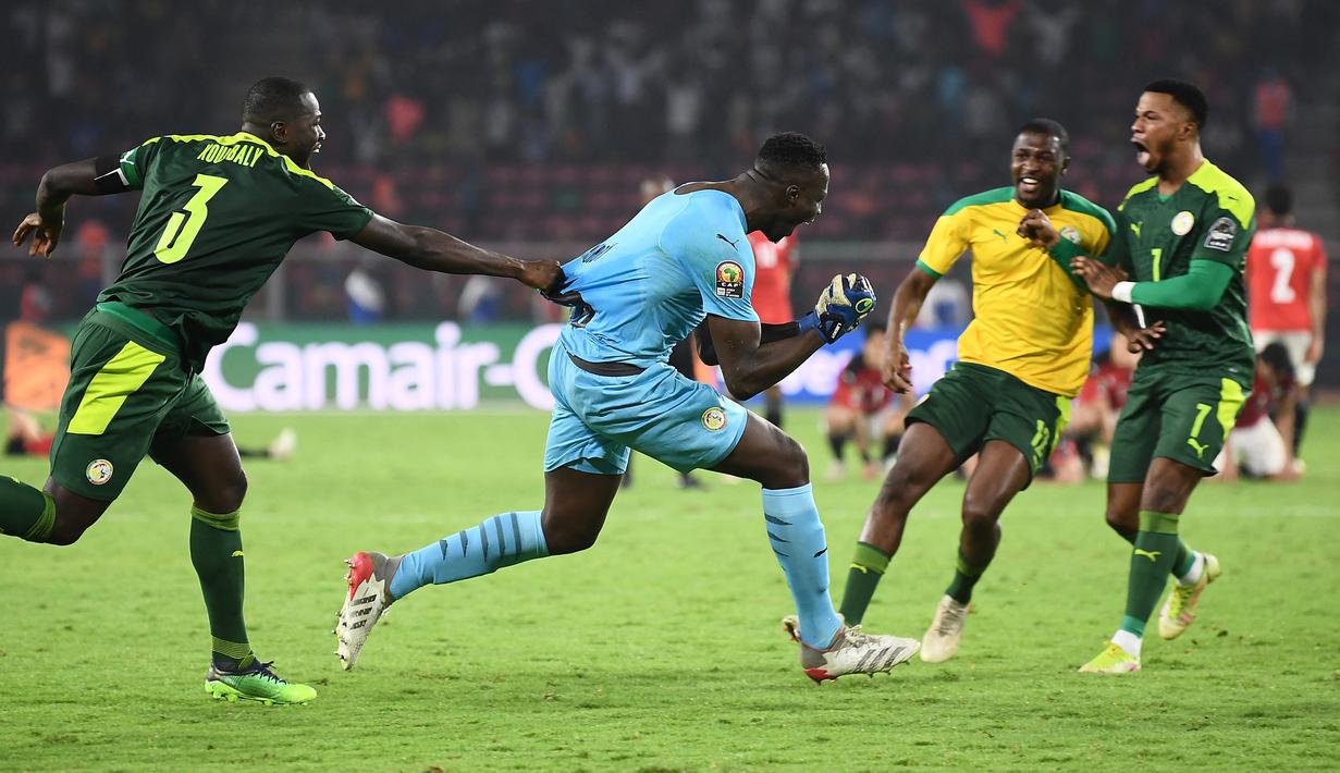 Kiper Senegal, Edouard Mendy (tengah) melakukan selebrasi bersama rekan setim usai memastikan menang adu penalti 4-2 (0-0) atas Mesir dalam laga final Piala Afrika 2021 di Stade d'Olembe, Yaounde, Kamerun (6/2/2022). (AFP/Charly Triballeau)