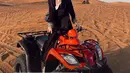Meski kenakan gamis, Aaliyah tak ragu naiki ATV untuk menikmati indahnya padang pasir. Apalagi dipadukan dengan tas dari YSL dan sandal putih yang kontras dengan outfit serba hitam [@aaliyah.massaid]