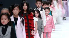 Model anak-anak membawakan busana rancangan KUNJIE oleh Liu Shuming  pada gelaran China Fashion Week di Beijing, China, Selasa (27/10/2020). (STR / AFP)