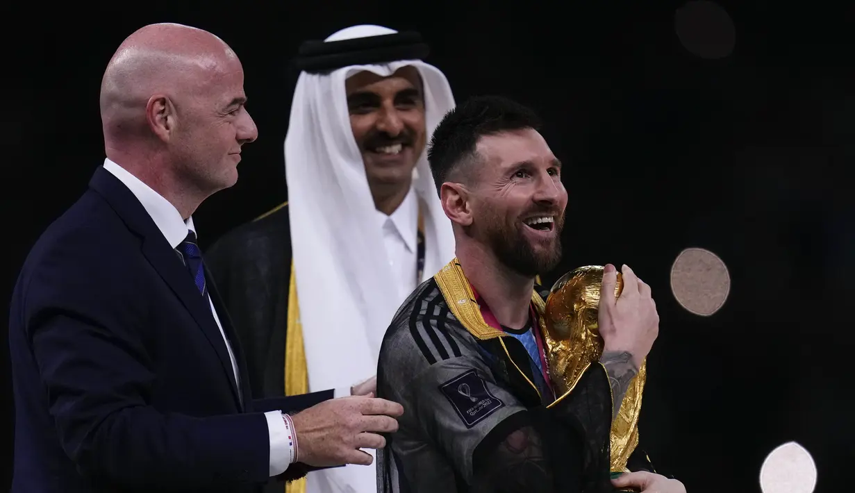 Lionel Messi memeluk trofi Piala Dunia yang ia dambakan sejak debutnya bersama Timnas Argentina di tahun 2006. (AP Photo/Manu Fernandez)