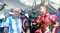 Warga tampak antusias berfoto bersama 2 super hero, yaitu Iron Man, Batman dan Captain America di TPS 21, Kelurahan Cigadung, Kecamatan Cibeunying Kaler, Kota Bandung. (Liputan6.com/Huyogo Simbolon)
