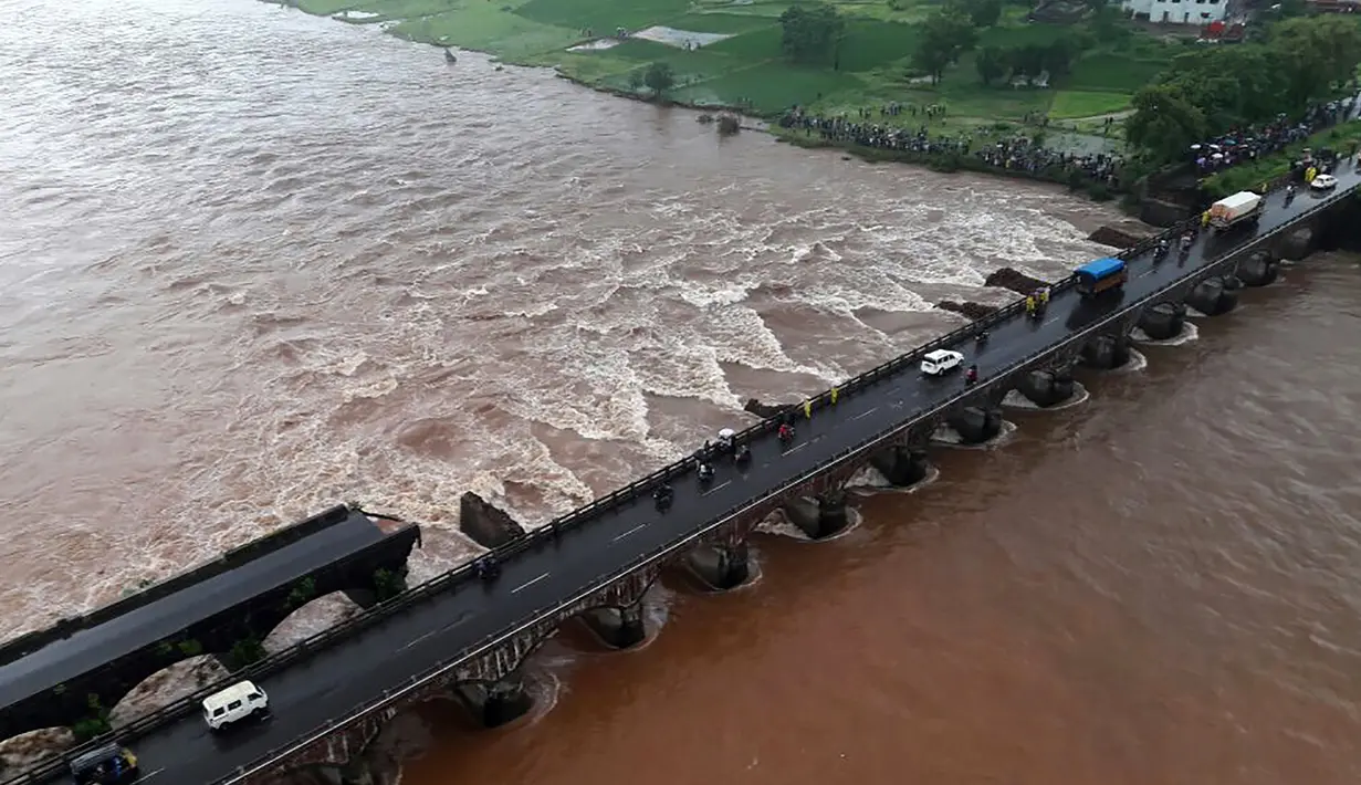 Salah satu dari dua jembatan utama yang menghubungkan kota Mumbai dengan negara bagian Goa di barat India runtuh di atas Sungai Savitri, Rabu (3/8). Dua bus yang membawa sedikitnya 22 penumpang terjun ke sungai berarus deras akibat hujan lebat. (AFP)