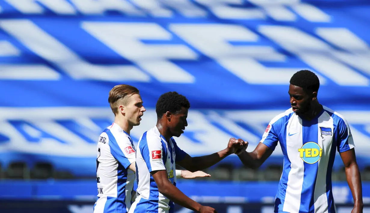 Para pemain Hertha Berlin merayakan gol yang dicetak oleh Javair Dilrosun ke gawang Augsburg pada laga Bundesliga di Olympiastadion, Sabtu (30/5/2020). Hertha Berlin menang 2-0 atas Augsburg. (AP/Hannibal Hanschke)