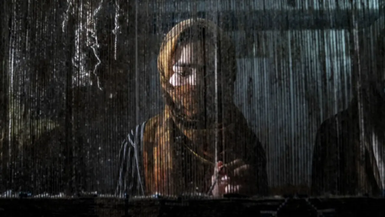 Seorang perempuan Afghanistan menenun karpet di pabrik karpet tradisional di Kabul pada 6 Maret 2023. (AP/Ebrahim Noroozi)