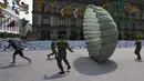 Pasukan terjun payung membantu seorang pria berlari dengan parasut terbuka dalam pameran yang disebut The Great Force of Mexico di Alun-Alun Zocalo, Mexico City, Meksiko, 20 September 2021. (ALFREDO ESTRELLA/AFP)