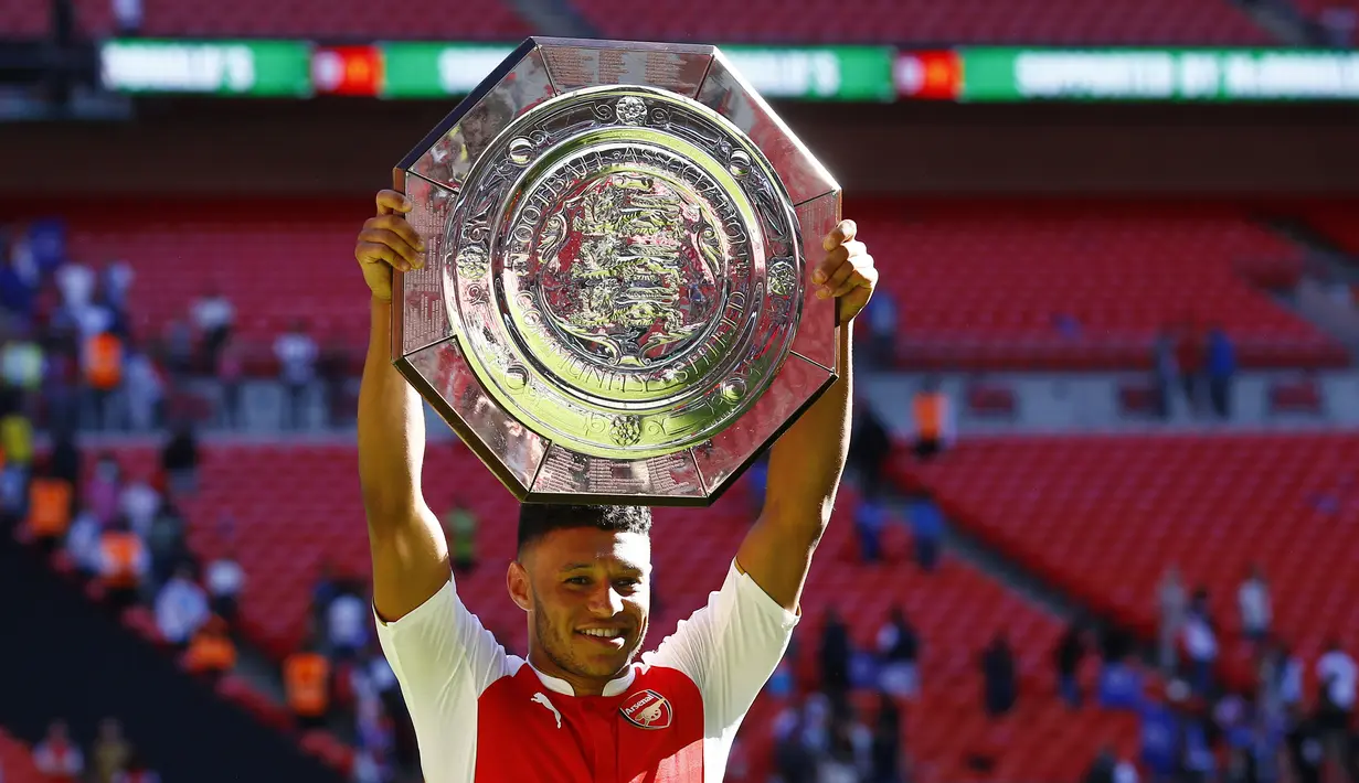 Pencetak gol kemenangan Arsenal atas Chelsea, Alex Oxlade-Chamberlain dengan trofi Community Shield 2015 di Stadion Wembley, Inggris. Minggu (2/8/2015) malam WIB. (Reuters/Darren Staples)