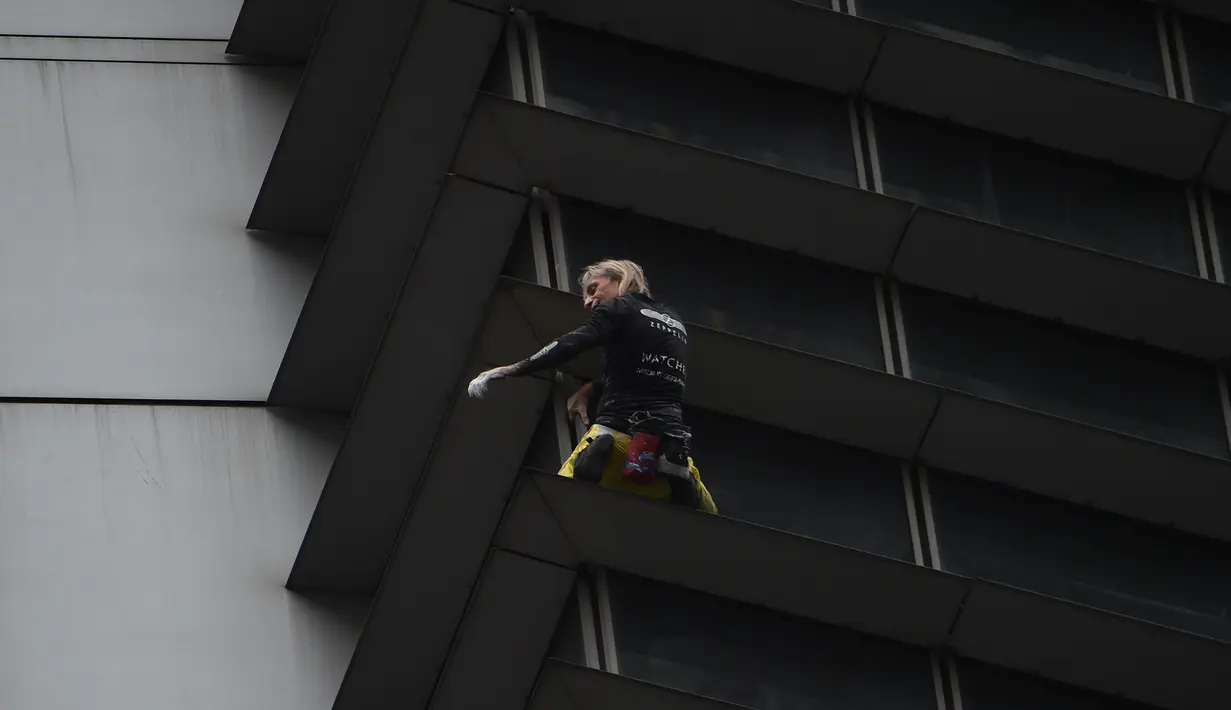 Alain Robert saat berusaha memanjat Menara Internasional GT berlantai 47 di Makati City, Manila, Filipina (29/1). Alain yang dikenal sebagai "The French Spiderman" kembali memanjat gedung pencakar langit di Filipina. (AFP Photo/Ted Aljibe)