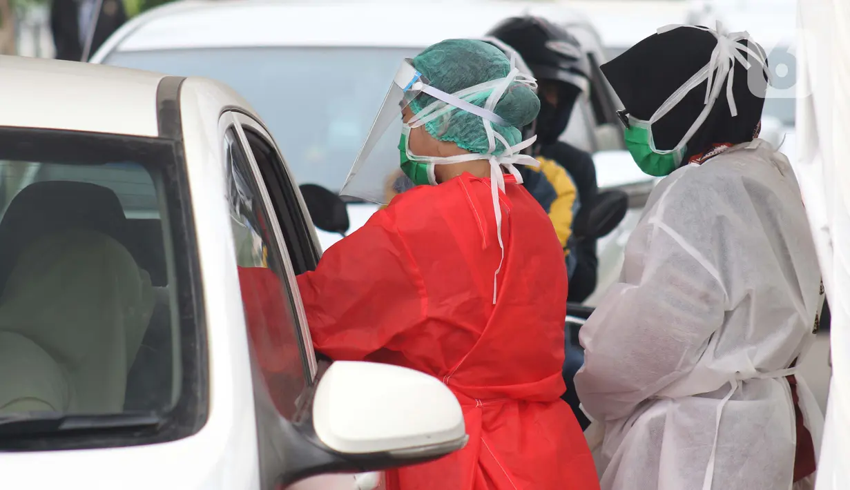 Petugas medis mengambil sample darah saat tes cepat diagnosa COVID-19 yang digelar secara drive thru di titik pengecekan Terminal Jatijajar, Depok, Jawa Barat, Kamis (28/5/2020). Tes cepat ini hasilnya langsung dikonfirmasi dan dilaksanakan hingga Jumat (29/5). (Liputan6.com/Helmi Fithriansyah)