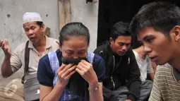 Seorang ibu tampak bersedih saat mengikuti doa bersama jelang penertiban permukiman Kampung Akuarium, Penjaringan, Jakarta, Senin (11/4). Mereka berdoa dengan khusuk di antara gang sempit, dengan menggelar terpal. (Liputan6.com/Gempur M Surya)