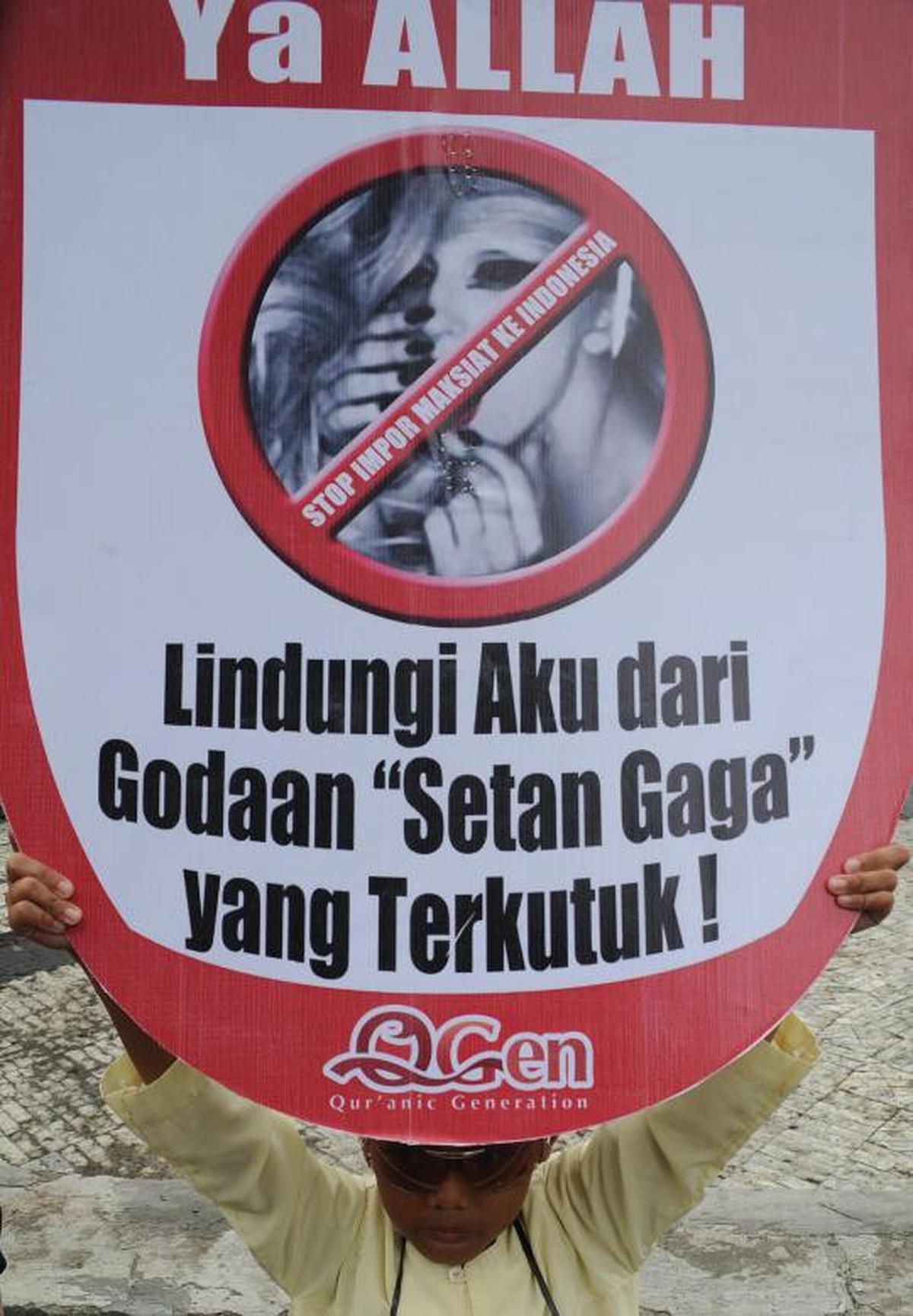 Seorang demonstran membawa poster penolakan konser Lady Gaga pada aksi 