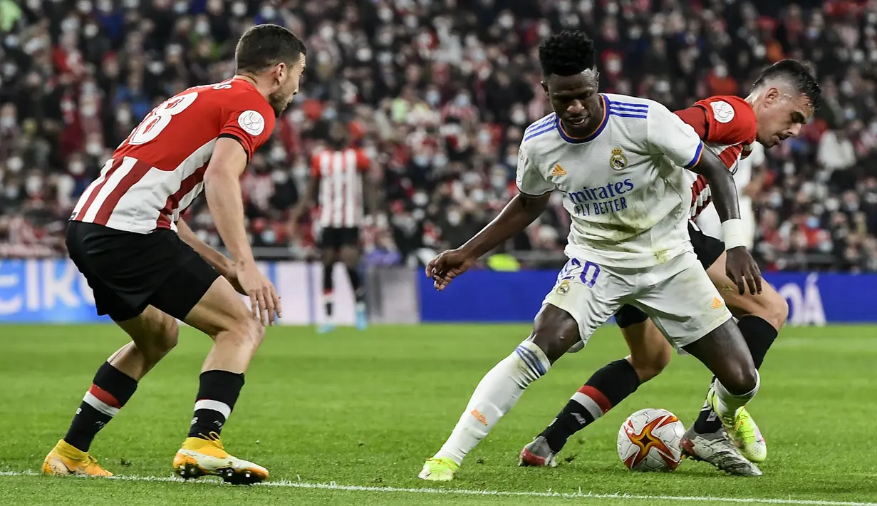 Penyerang Real Madrid Vinicius Junior berebut bola saat dijamu Athletic Bilbao pada perempat final Copa del Rey di San Mames, Jumat (4/2/2022) dinihari WIB. Real Madrid tersisih dari Copa del Rey setelah kalah 0-1 dari Athletic Bilbao. (AP Photo/Alvaro Barrientos)