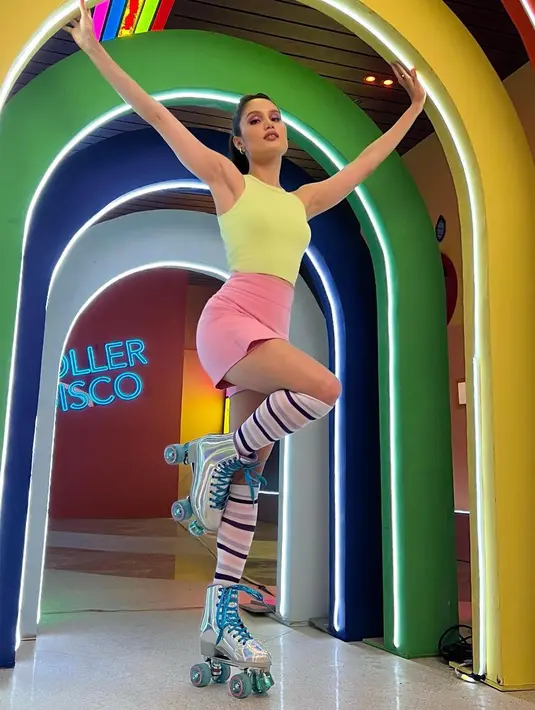 Warna-warna pastel seperti terlihat pada outfit Cinta dalam foto ini juga bisa jadi inspirasi menarik. Tabrak warna antara tank top kuning dengan celana pendek pink, dipadu kaus kaki panjang bergaris bernuansa merah muda terlihat apik ketika dikenakan Cinta Laura. Foto: Instagram.