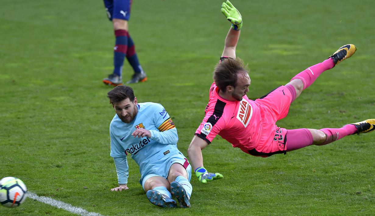Lionel Messi (kiri) berusaha menjangkau bola dari adangan kiper Eibar, Marko Dmitrovic pada lanjutan La Liga Santander di Ipurua stadium,  Eibar, (17/2/2018). Barcelona menang 2-0. (AFP/Ander Gillenea)