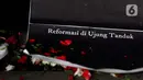 Poster yang dibawa pegiat Antikorupsi yang menamakan diri Rakyat Indonesia Peruwat KPK saat melakukan aksi teatrikal "Ruwatan" di Lobby Gedung Anti-Corruption Learning Center (ACLC) KPK, Jakarta, Jumat (28/5/2021). Ruwatan ini sebagai simbol pengusiran energi jahat. (Liputan6.comHelmi Fithriansyah)