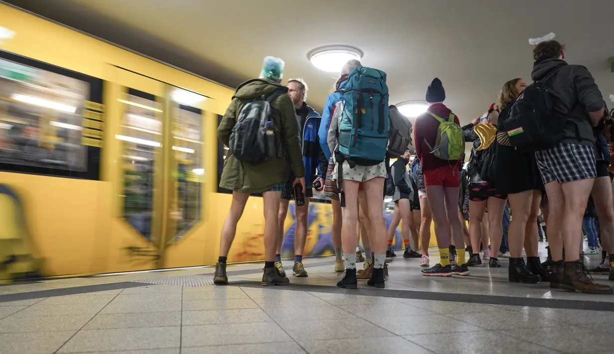 Penumpang tanpa menggunakan celama menunggu kereta di subway selama acara tahunan No Pants Subway Ride di Berlin pada Minggu (12/1/2020). New York menjadi kota pertama yang menghajat acara naik kereta tanpa celana ini sejak tahun 2002. (Jörg Carstensen / dpa / AFP)