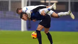 Pemain Empoli Simone Romagnoli melompat ke atas pemain Inter Milan Joaquin Correa pada pertandingan sepak bola Coppa Italia di Stadion San Siro, Milan, Italia, 19 Januari 2022. Inter Milan menang 3-2. (AP Photo/Antonio Calanni)