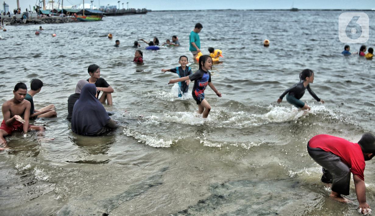 Wisatawan memadati Pantai Ancol saat mengisi libur Natal, Jakarta, Minggu (25/12/2022). Kepala Komunikasi PT Pembangunan Jaya Ancol Ariyadi Eko Nugroho mengungkapkan per hari ini jumlah wisatawan di Taman Impian Jaya Ancol tembus 40.000, angka tersebut meningkat dua kali lipat dibanding libur hari biasa maupun Natal tahun 2021. (merdeka.com/Iqbal S. Nugroho)