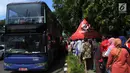 Antrean warga menaiki bus tingkat untuk wisata keliling Ibu Kota di depan Masjid Istiqlal, Jakarta, Sabtu (31/3). Libur tiga hari di penghujung Maret 2018 dimanfaatkan untuk berkeliling Jakarta menggunakan bus tingkat City Tour. (Merdeka.com/Imam Buhori)