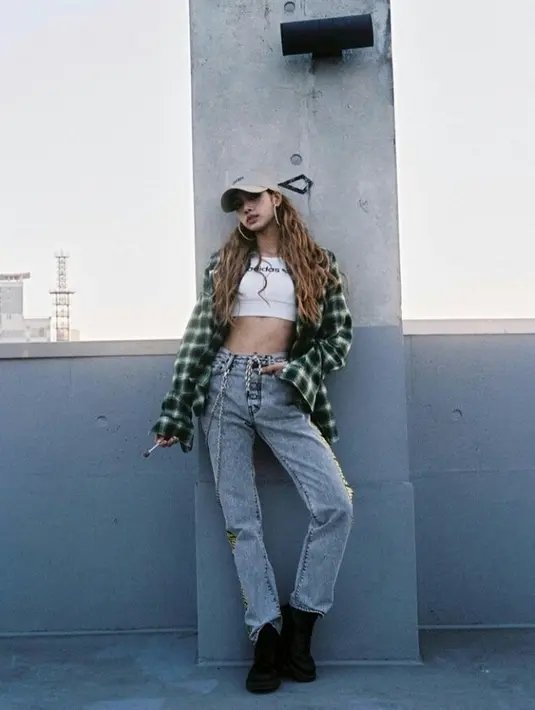 Lisa tampil kece dengan crop tee, kemeja flanel, jeans, black boots. Tak lupa topi dan hoop earrings sebagai aksesori pelengkap (Instagram/lalalalisa_m).