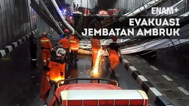 Pasca-ambruknya jembatan di Pasar Minggu Jakarta Selatan, sejumlah petugas melakukan evakuasi dengan memotong besi yang melintang di jalan.