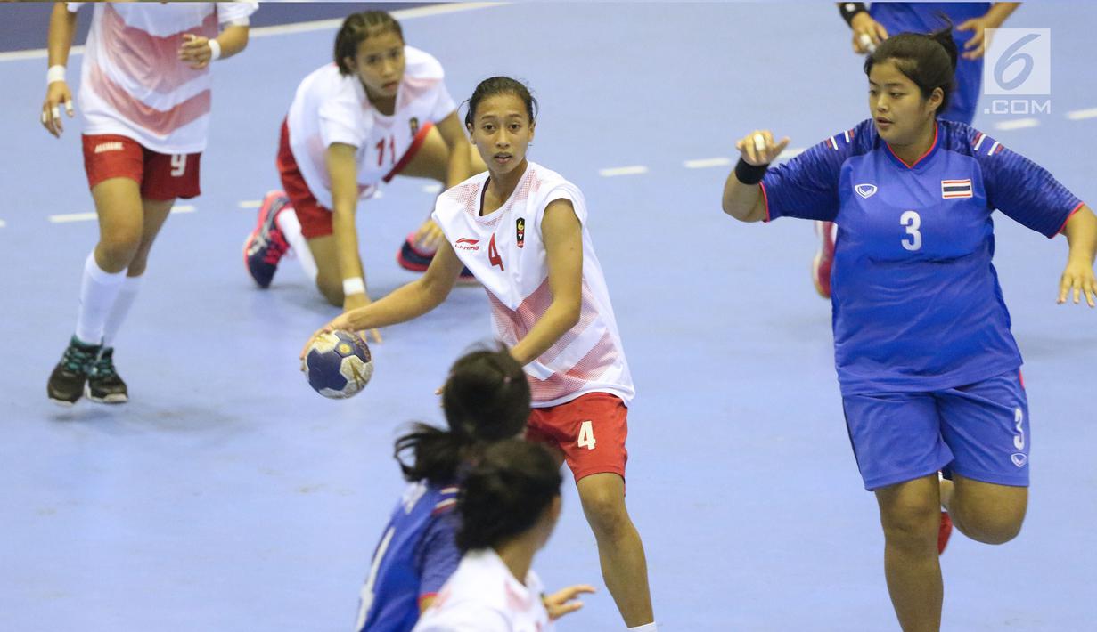 Pemain bola tangan putri Indonesia, Fitri Anggi Yani (tengah) mencoba mengatur serangan saat melawan Thailand pada babak penyisihan grup B Asian Games 2018 di Jakarta, Kamis (16/8). Indonesia kalah 16-34. (Liputan6.com/Helmi Fithriansyah)