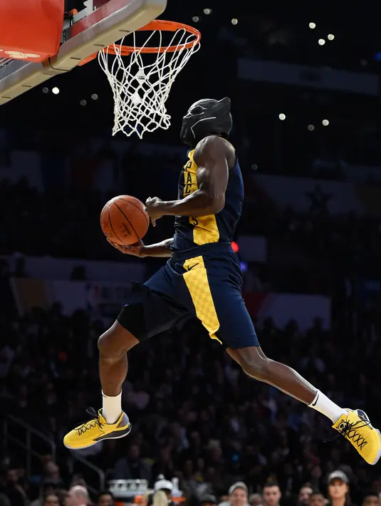 Pemain Indiana Pacers, Victor Oladipo menggenakan topeng dari film "Black Panther" berusaha memasukan bola ke dalam ring pada kontes basket All-Star NBA All-Star 2018 di Los Angeles, AS (17/2). (AP Photo/Chris Pizzello)
