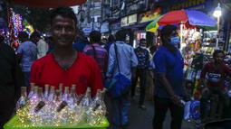 Seorang pedagang menjual lampu hias di jalan menjelang Diwali, festival lampu Hindu, di Kolkata, India, Rabu (27/10/2021). Diwali, festival lampu, dirayakan pada 4 November. (AP Photo/Bikas Das)