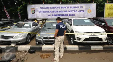 Petugas melakukan pengecekan barang bukti pengungkapan kasus pencurian dan penggelapan mobil di halamanPolda Metro Jaya, Jakarta, Minggu (6/12/2015). Subdit 6/Ranmor Ditreskrimum Polda Metro menahan  . (Liputan6.com/Helmi Fithriansyah)
