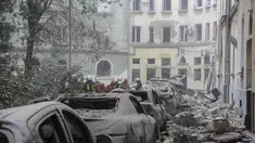 Petugas layanan darurat berkumpul di luar bangunan yang rusak saat pencarian korban berlanjut setelah serangan rudal Rusia di Lviv, Ukraina, Kamis, 6 Juli 2023. (AP Photo/Mykola Tys)